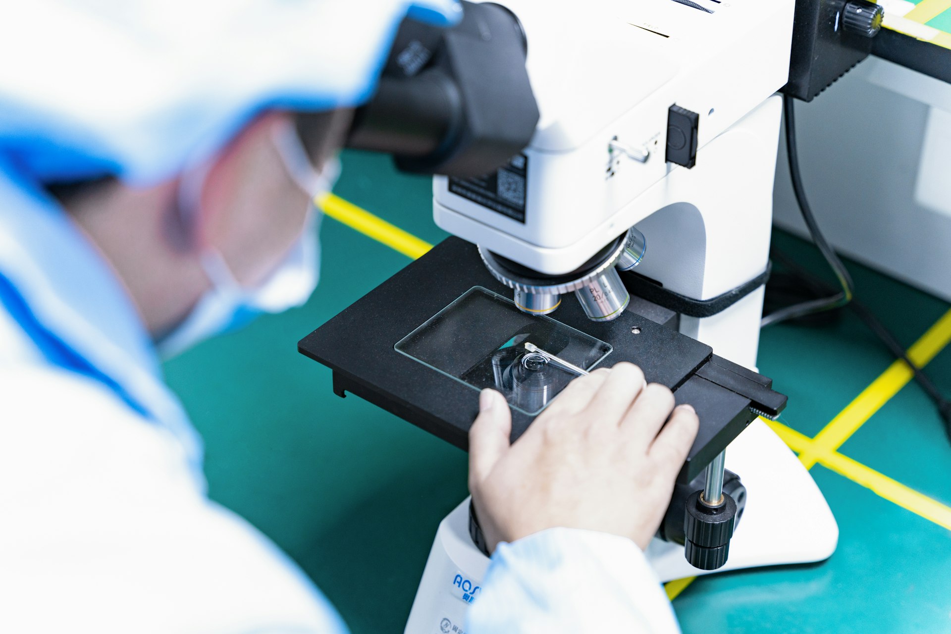 a man looking through a microscope at something